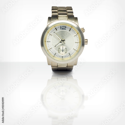 Wristwatch with reflection on white glossy table