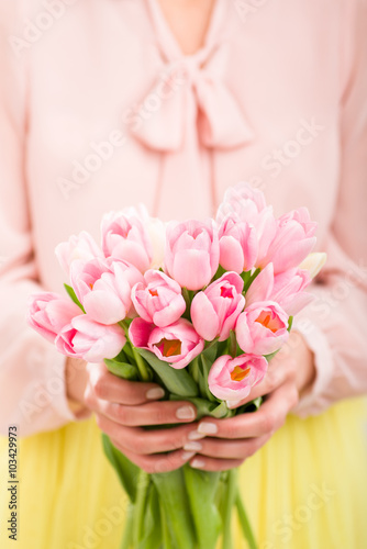 Fototapeta Naklejka Na Ścianę i Meble -  Bunch of tulips in woman's hands, shallow dof.
