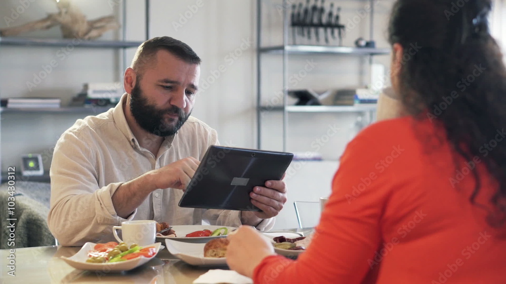 Young couple during breakfast at home, man using tablet computer
Young couple during breakfast at home, man using tablet computer