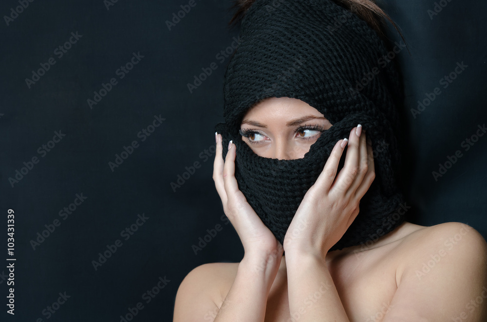 Beautiful face of a lady cover her head and face with a black wool scarf, shoulders uncovered Beautiful face of a lady cover her head and face with a black wool scarf, shoulders uncovered