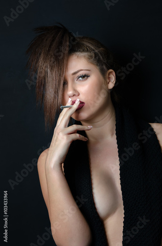 Pretty lady with a pony tail front of her face, covering her nude body with a black wool scarf and holding a cigar