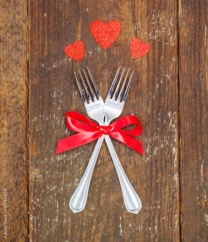 Couple  forks with hearts on wooden board, Valentines Day dinner