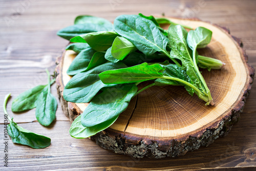Spinach leaves on wooden circle