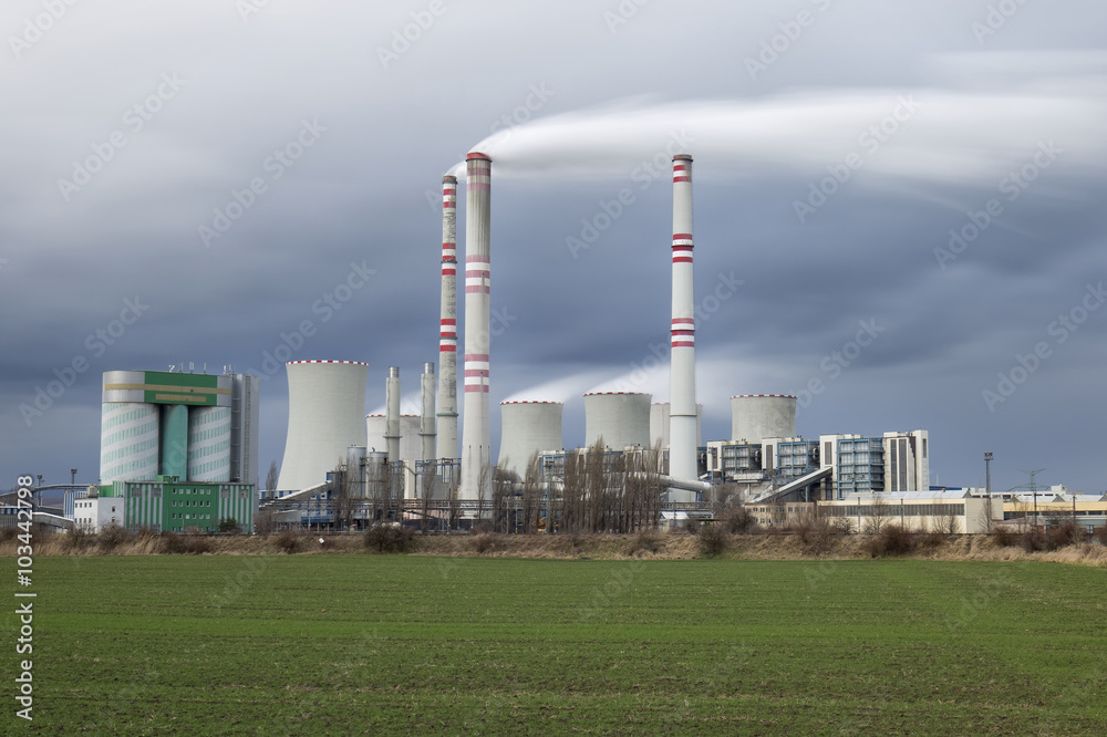 A coal-fired power station in the distance in agricultural landscape. Pocerady, Czech republic