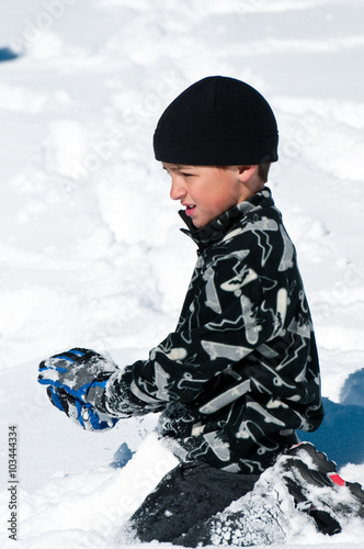 Cute boy playing in the snow. photo