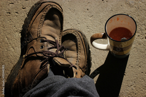 Old shoes and cup with squeezed fruit