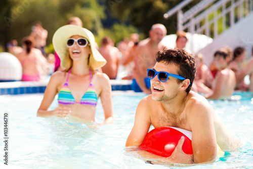 Couple with sunglasses in swimming pool. Summer and water.