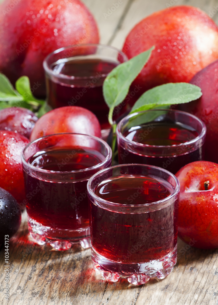 Fresh fruit juice of red plums and peaches, selective focus Fresh fruit juice of red plums and peaches, selective focus
