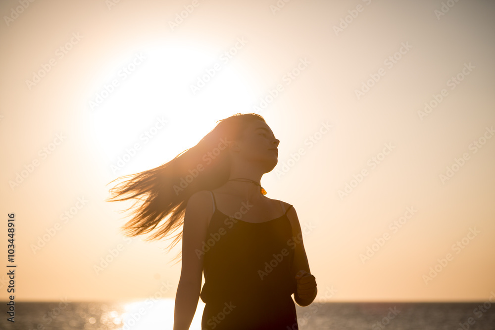 sunset and silhouette of a teenage girl in motion