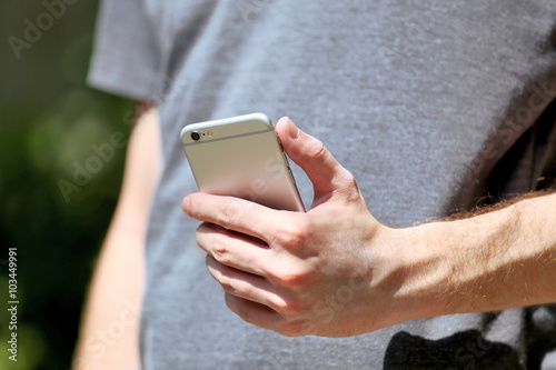 Man holding smart mobile phone outdoors