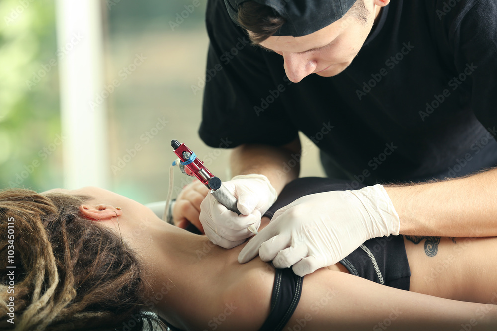 Tattooist makes tattoo, close up Tattooist makes tattoo, close up