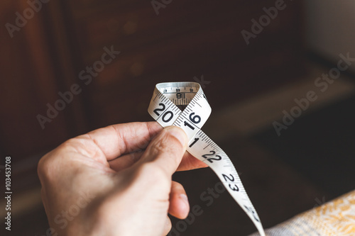 Foto 2016. Man hand holding sewing centimeter