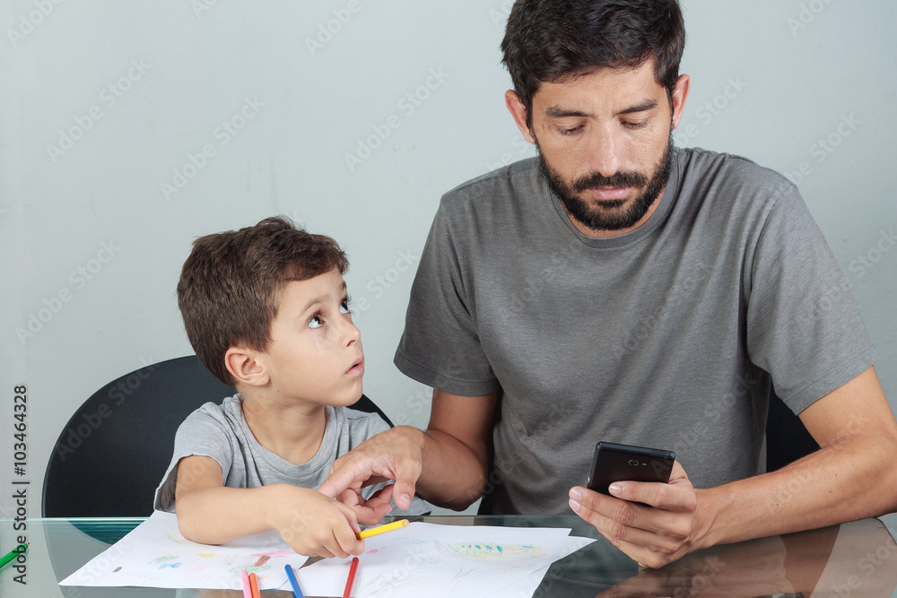 Father using smartphone ignoring his son Father using smartphone ignoring his son