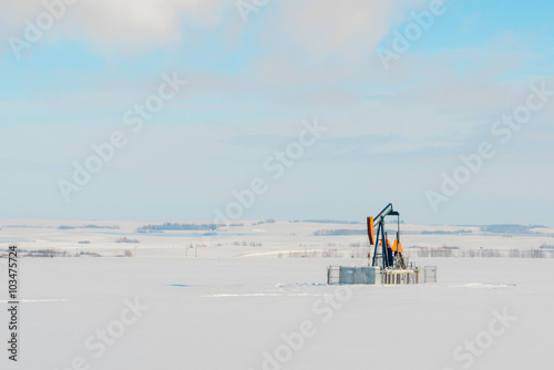 Lone Pumpjack in Snowy Field