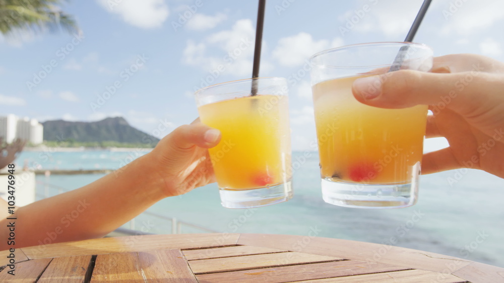 Beach bar party drinking friends toasting Hawaiian sunset cocktails having fun. Close up of woman holding alcoholic drink cheering in Waikiki beach, Honolulu, Oahu, Hawaii, USA. RED EPIC SLOW MOTION.