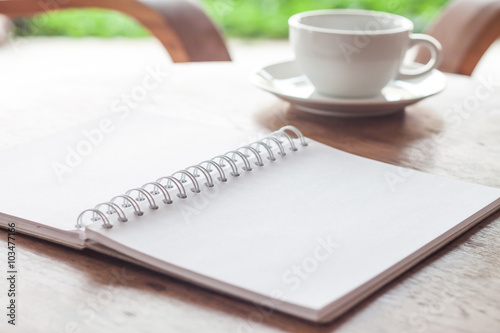 Open blank white notebook with cup of coffee