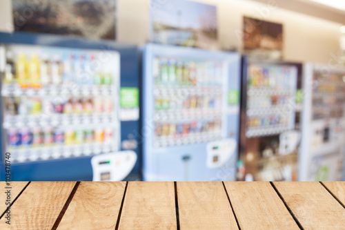 Empty top wooden table and blurred image of vending machine