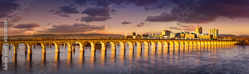 Philadelphia and Reading Railroad Bridge crosses Susquehanna river at sunset. Harrisburg skyline shines under a late afternoon light.