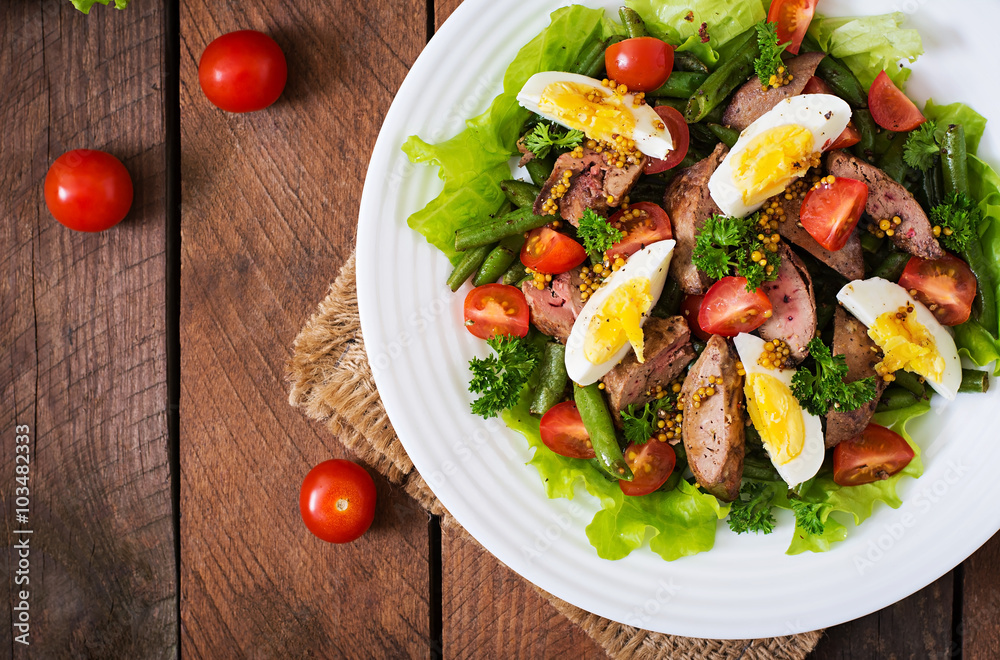 Warm salad with chicken liver, green beans, eggs, tomatoes and balsamic dressing. Top view