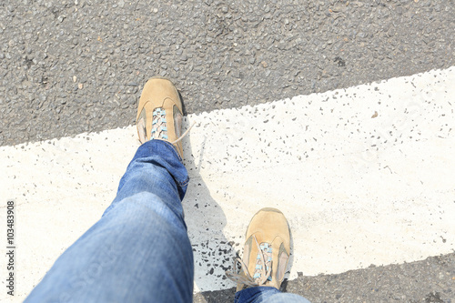 people legs walking on zebra crossing road