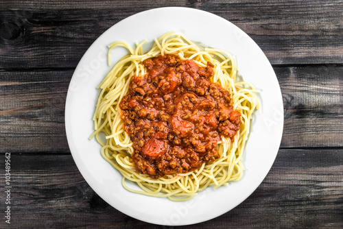 Cooked spaghetti bolognese on white plate.