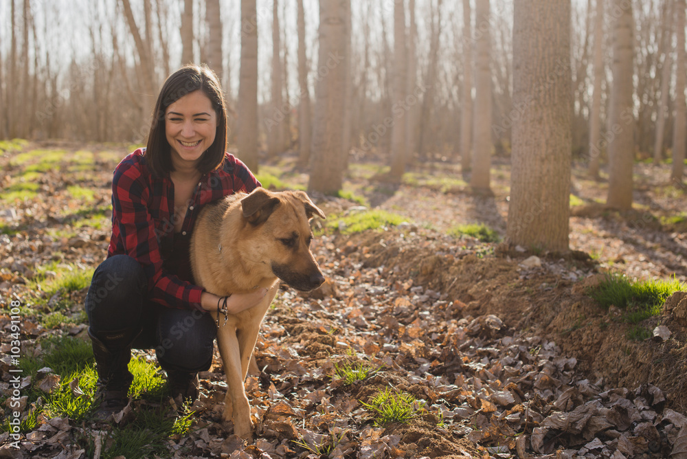 Woman Enjoying a Winter Day with Her Dog in the Forest Woman Enjoying a Winter Day with Her Dog in the Forest