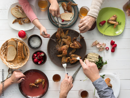 Fotografie family having roasted chicken wings for dinner