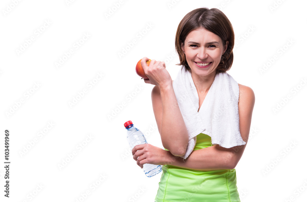 sport girl holding apple and water with towel on her neck sport girl holding apple and water with towel on her neck
