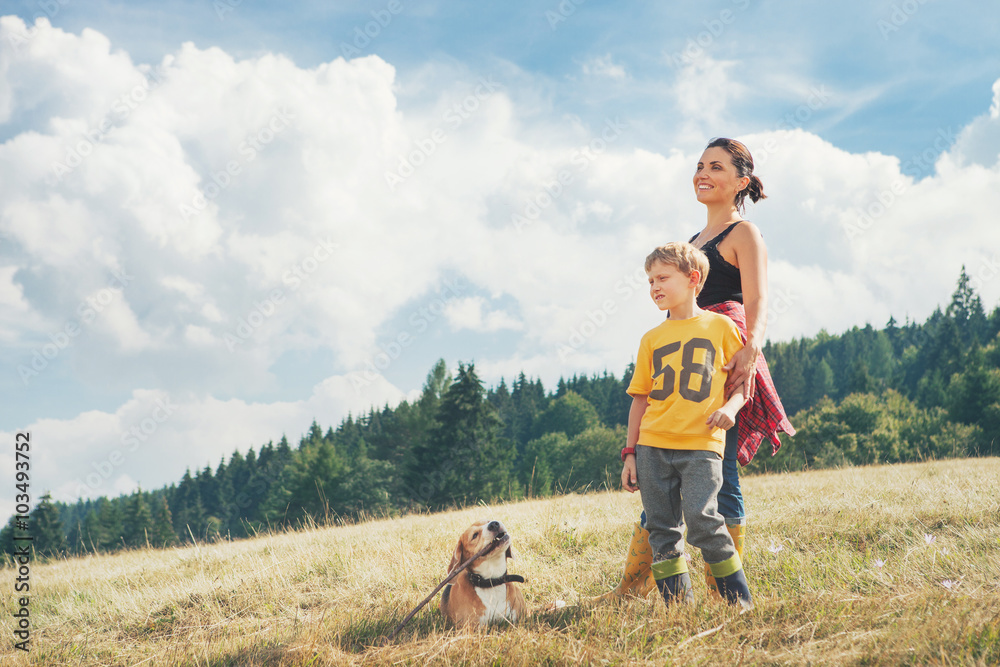 Mother with son and his dog walk on the golden field Mother with son and his dog walk on the golden field