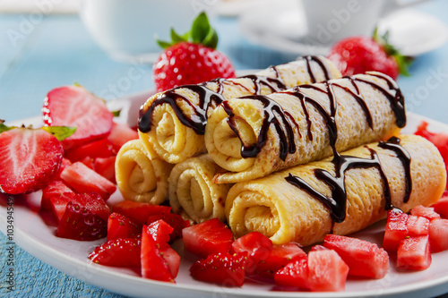 rolled pancakes with strawberries and chocolate breakfast