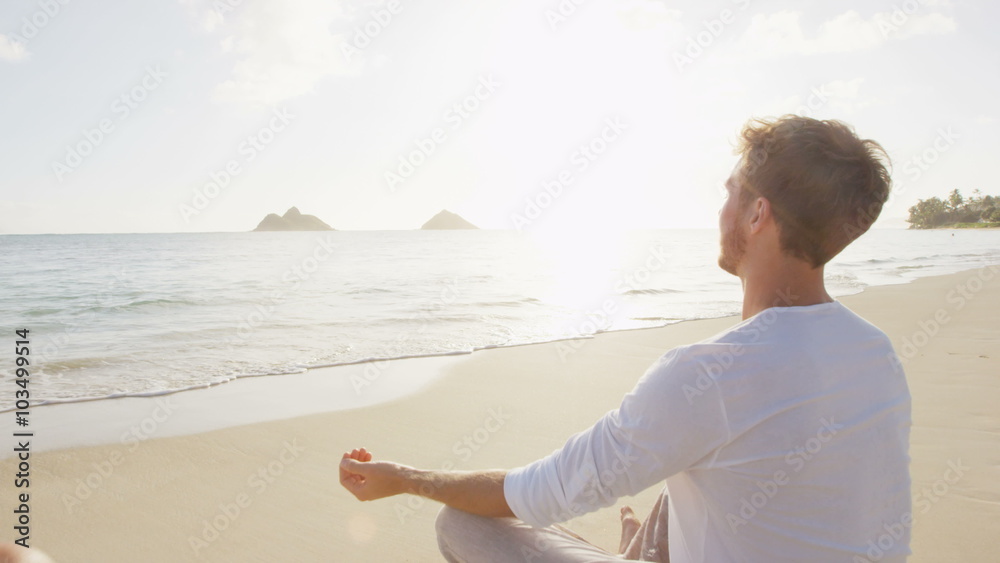 Meditation and Yoga. People meditating in lotus pose relaxing outside on beach at sunrise. Couple woman and man in serene ocean landscape. Lanikai beach, Oahu, Hawaii, USA. Meditation and Yoga. People meditating in lotus pose relaxing outside on beach at sunrise. Couple woman and man in serene ocean landscape. Lanikai beach, Oahu, Hawaii, USA.