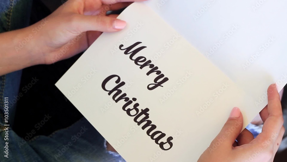 Woman Opens The Card. Marry Christmasis Written in the card. Woman Opens The Card. Marry Christmasis Written in the card.