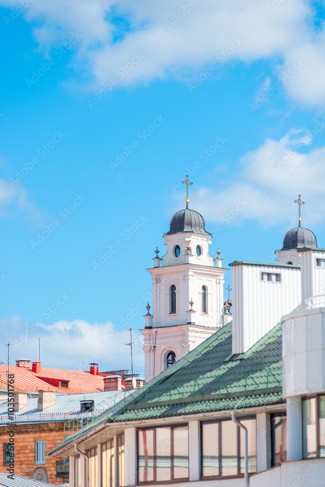 rooftops and church steeple against a blue sky