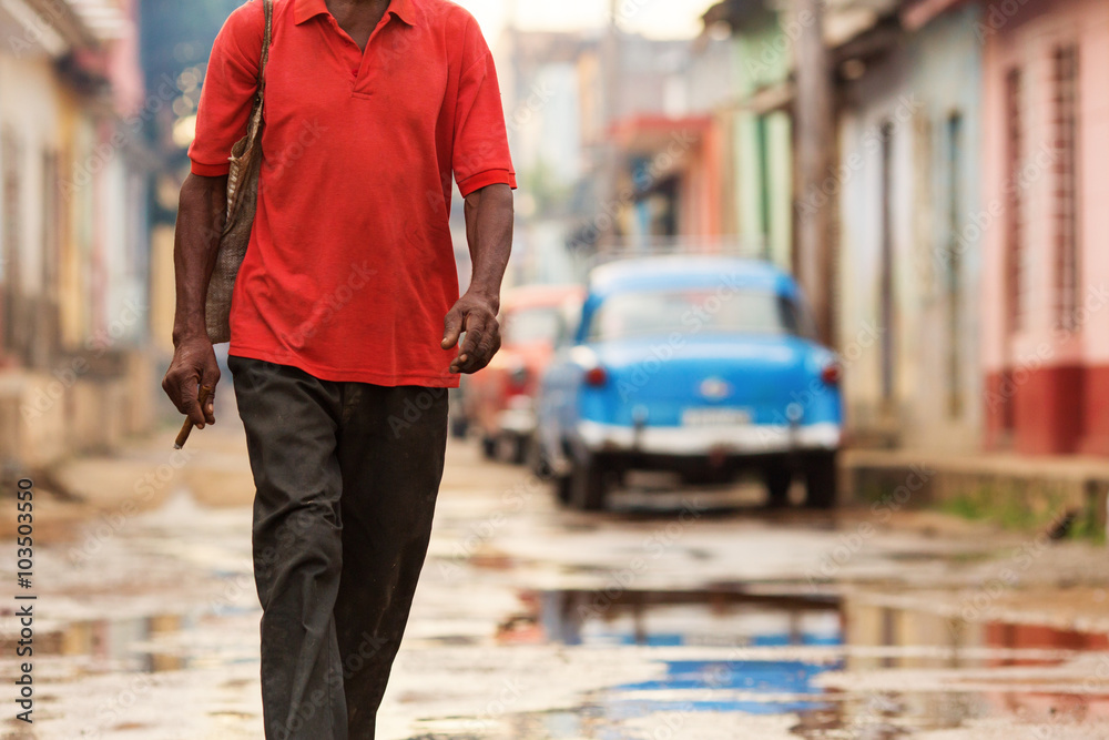 Man with cigar walking on street of Trinidad, Cuba Man with cigar walking on street of Trinidad, Cuba