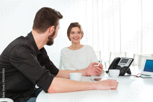 Two business people sitting and talking in office