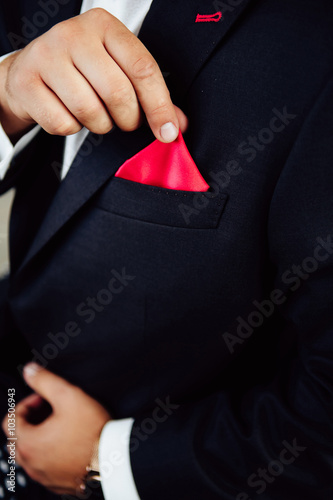 Close-up shot of a groom wearing handkerchief.