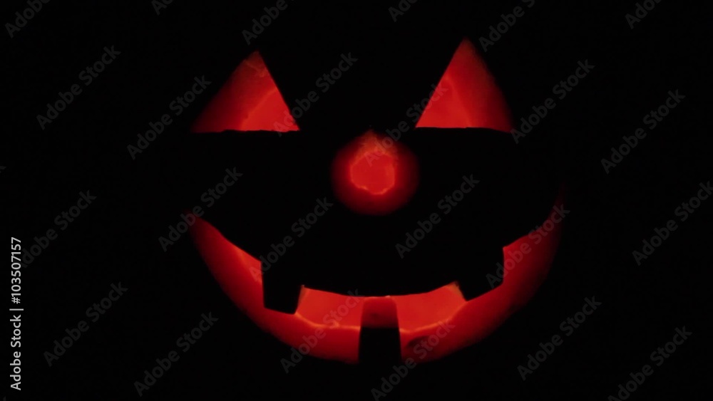 Halloween. Holiday Glowing Pumpkin is in The dark. Nearby are two candles. Angry face. Halloween. Holiday Glowing Pumpkin is in The dark. Nearby are two candles. Angry face.