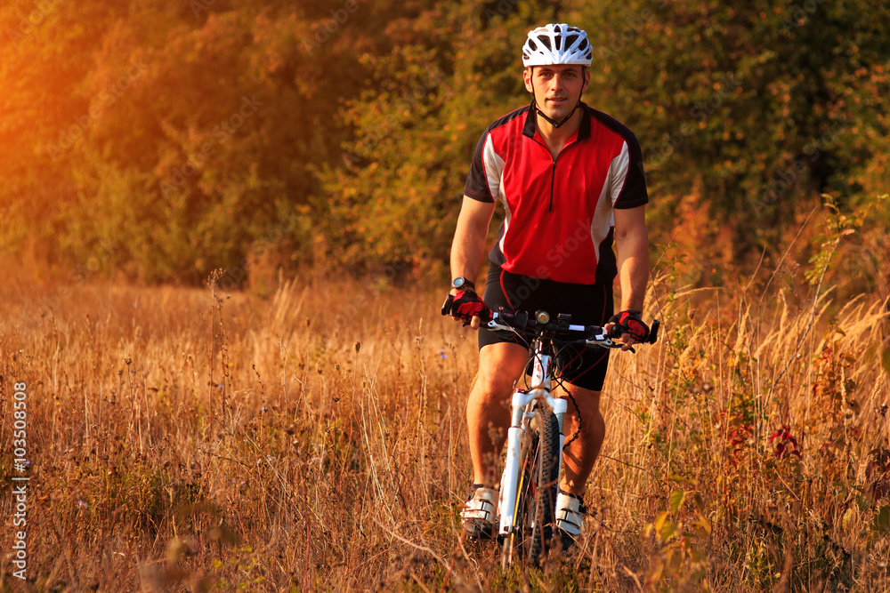 Obraz premium Man is riding a mountain bike in the field