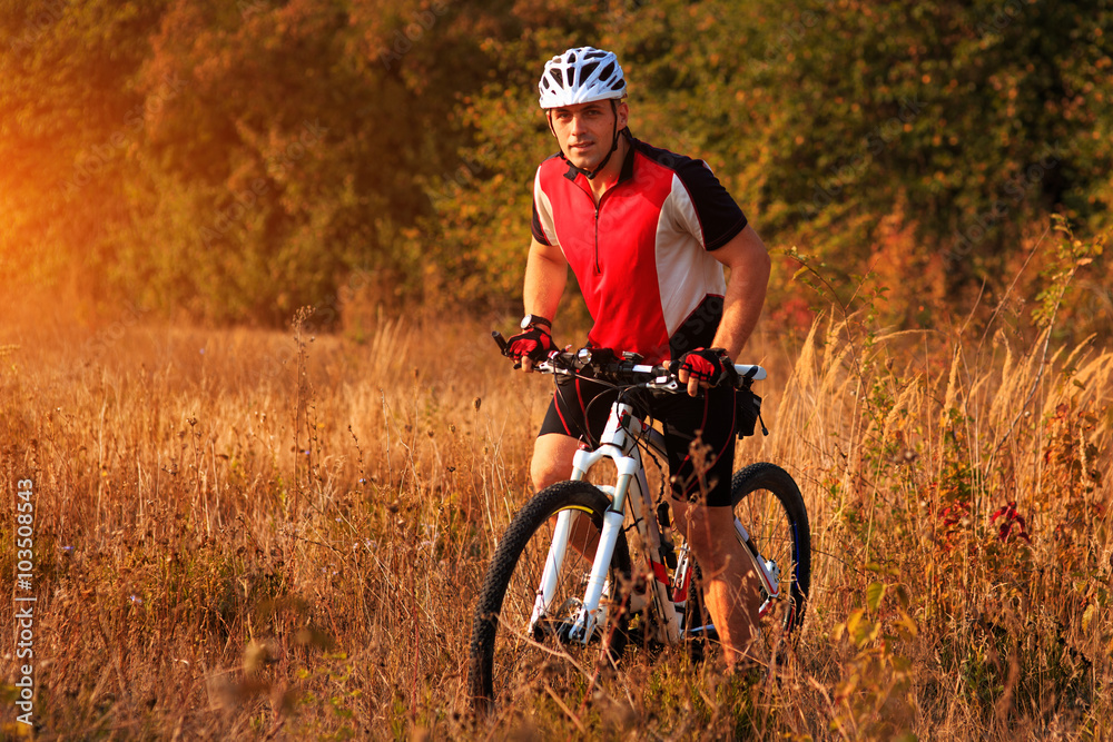 Man is riding a mountain bike in the field