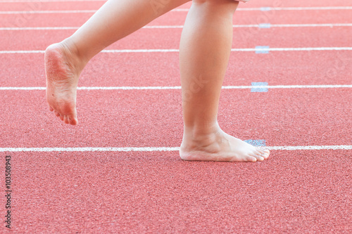 Walking barefoot on a red treadmill