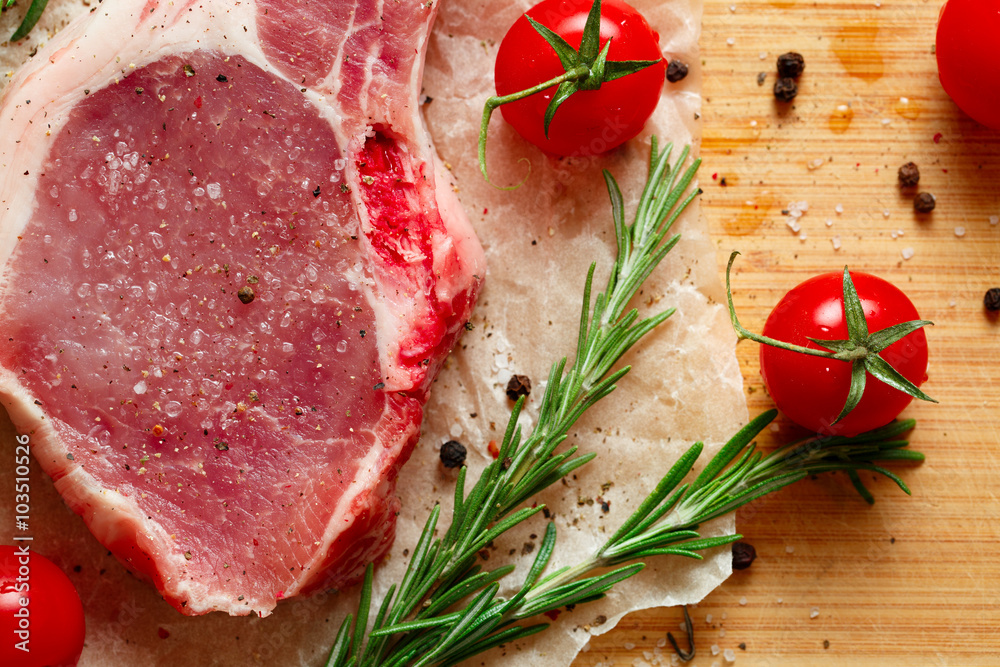 Pieces of crude meat with rosemary and tomatoes. Pieces of crude meat with rosemary and tomatoes.
