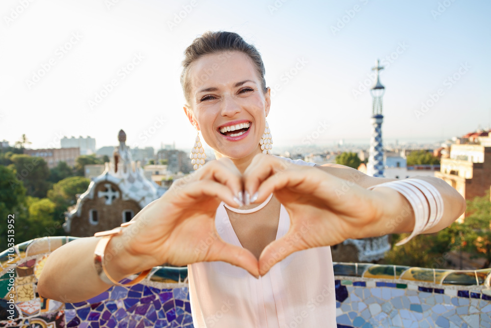 Fototapeta premium Woman tourist showing heart shaped hand in Park Guell, Barcelona