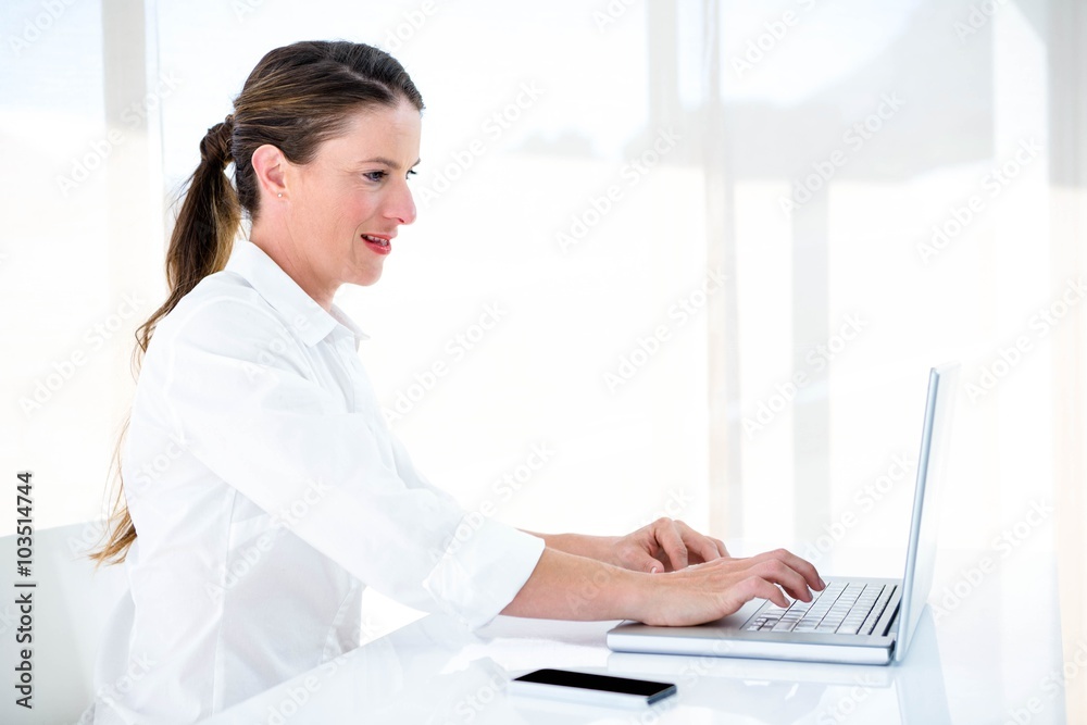 smiling business woman typing on her laptop smiling business woman typing on her laptop