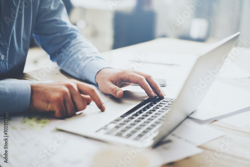 Businessman working laptop for new architectural project. Generic design notebook on the table. Blurred background, horizontal mockup.