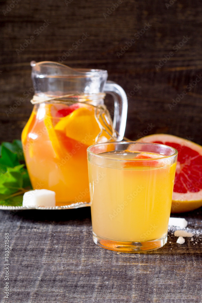 The drink of fresh grapefruit on a dark wooden table The drink of fresh grapefruit on a dark wooden table