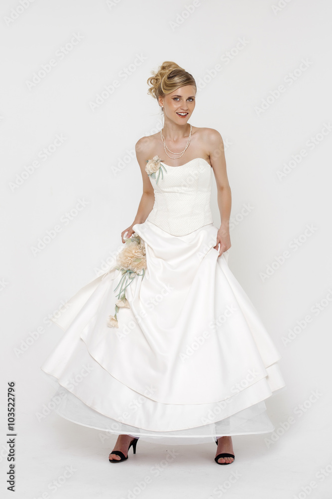 Portrait of gorgeous bride wearing wedding dress over grey backg