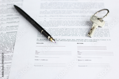 Legal document for sale of real estate, with a gold-nibbed fountain pen and house keys