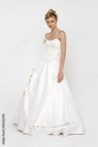 Portrait of gorgeous bride wearing wedding dress over grey backg