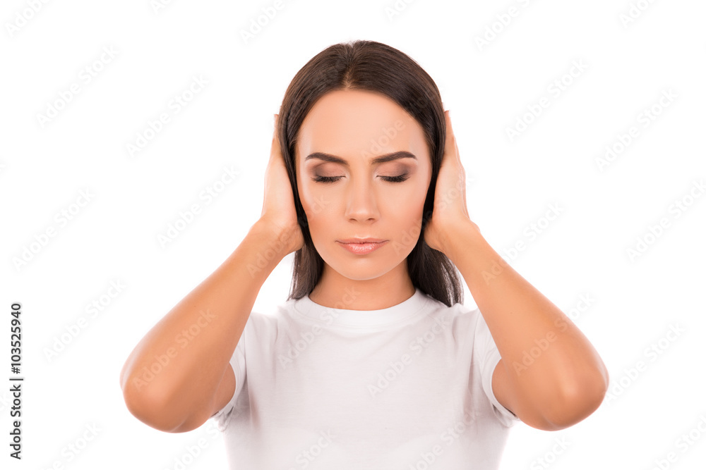Calm young woman covering her ears and trying to focus Calm young woman covering her ears and trying to focus