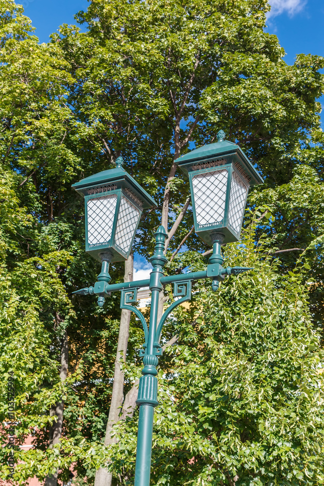 Old-fashioned street lamp against the trees. Moscow, Russia.